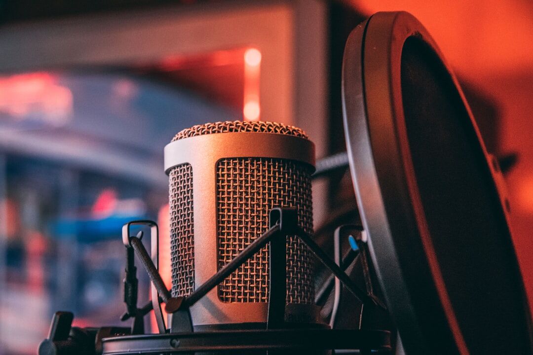 Person practicing voice training with a microphone and pop filter