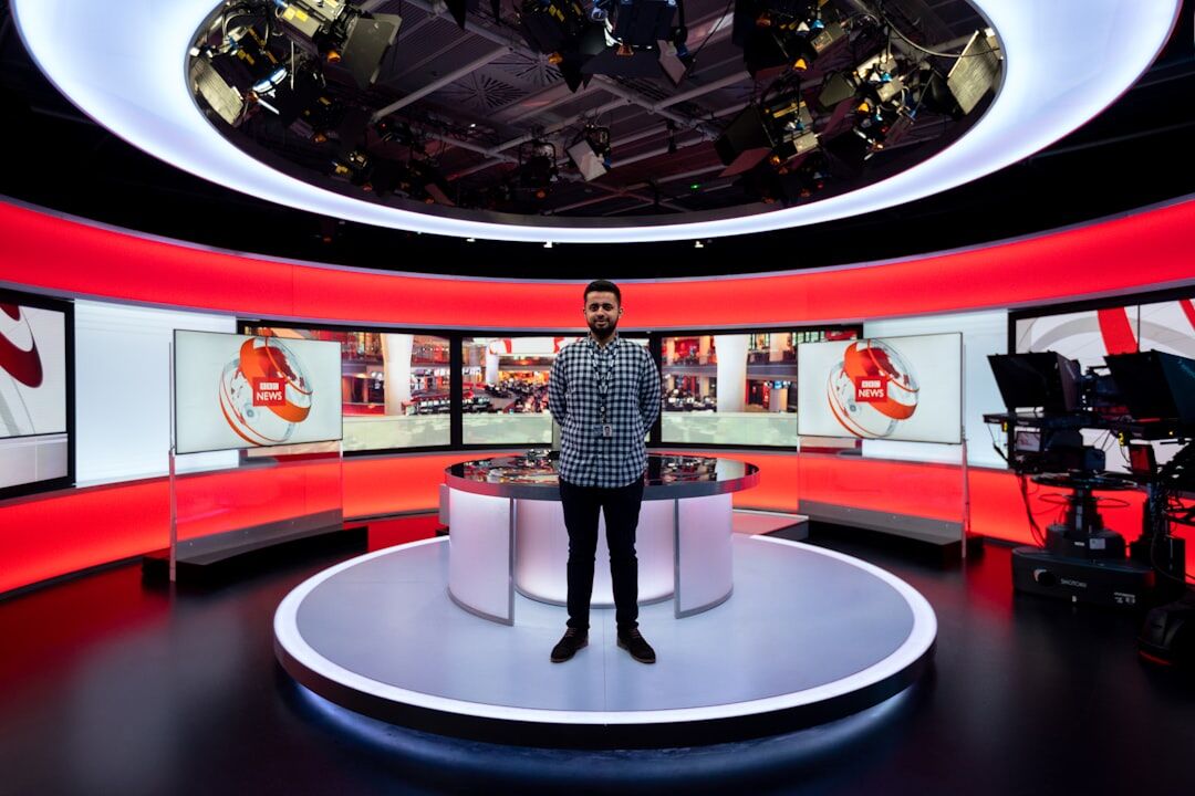 Female TV presenter holding a microphone in a broadcast studio